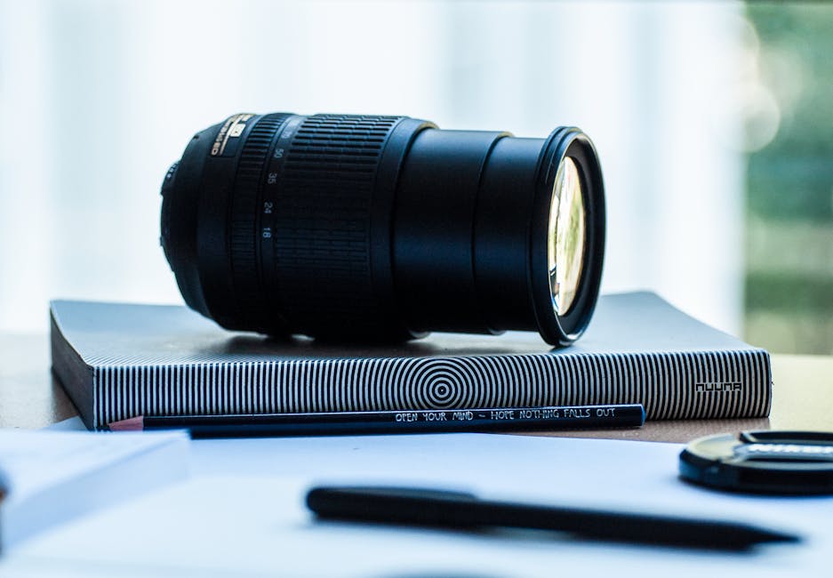Camera lens resting on a stylish notebook, ideal for photography enthusiasts.