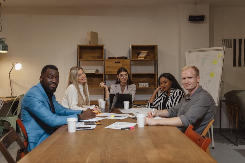 A diverse group of professionals engaged in a productive meeting in a contemporary office environment.